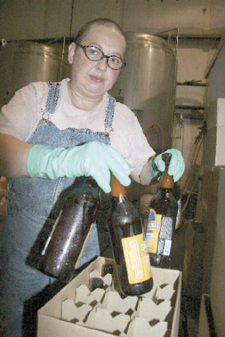 Snoqualmie Falls Brewing Company Assistant Brewer Janelle Pritchard cases up newly filled bottles of beer