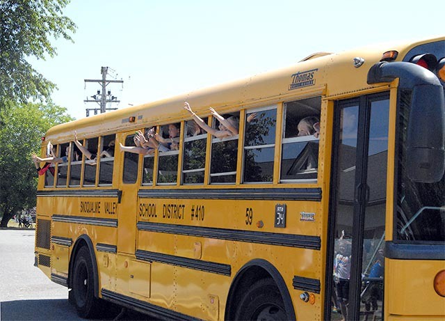 Students wave excited goodbyes as their buses pull out of Fall City Elementary School.