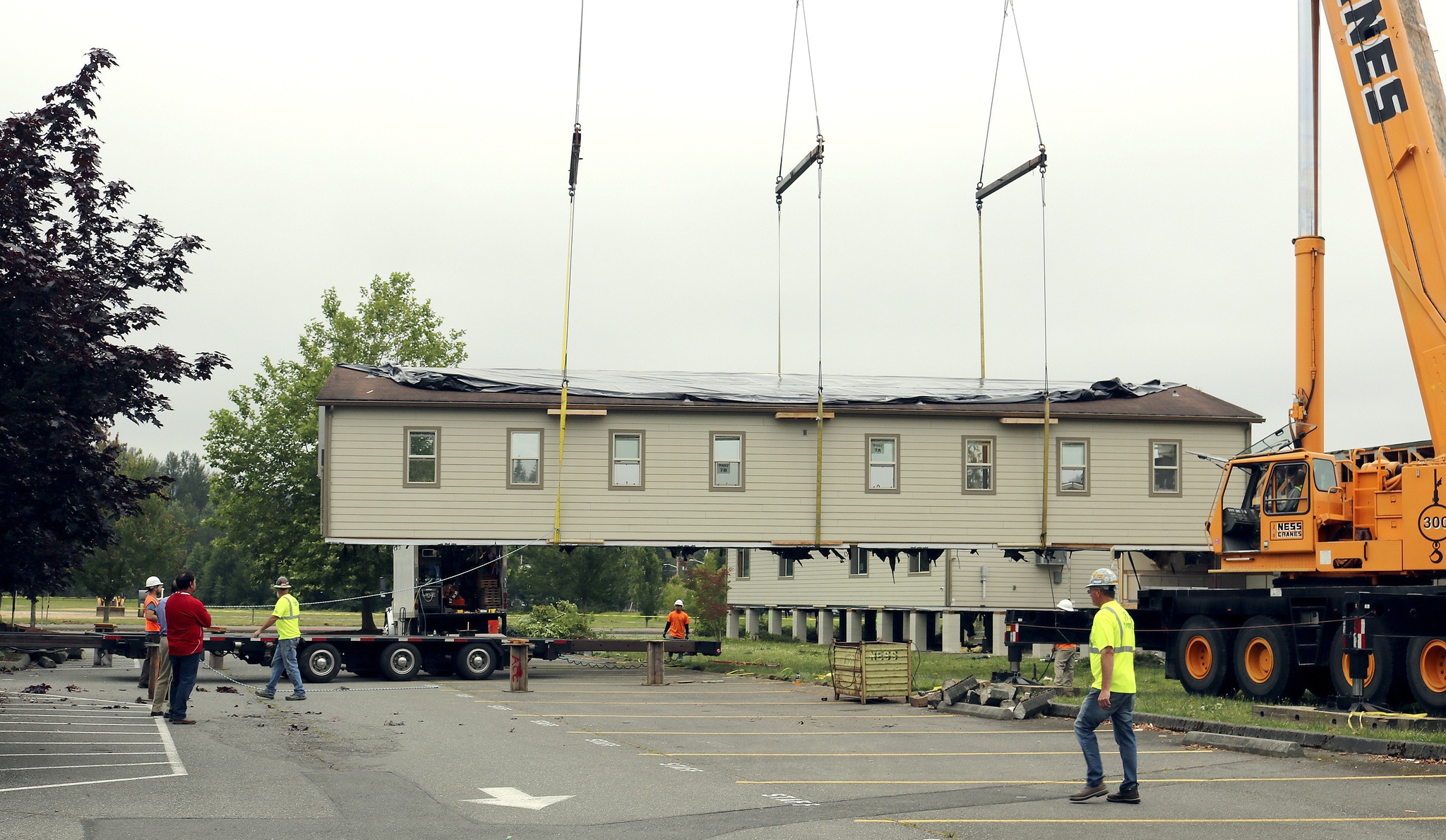 Evan Pappas/Staff PhotoA portable classroom at Mount Si High School is lifted off of its supports and onto a truck. The crew surrounds the building to make sure it is placed on the truck bed properly.