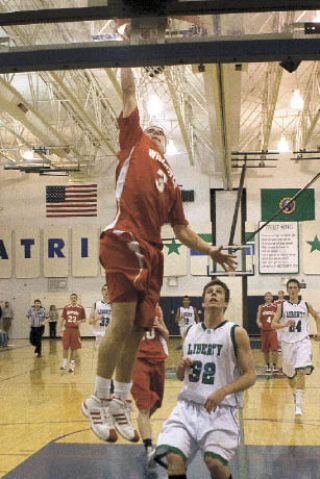 Mount Si’s Tanner Riley jams one over Eric Peterson of Liberty during the Friday