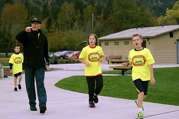 Coach Dutch Siedentopf directs the runners along the path at Tollgate Farm Park in North Bend.