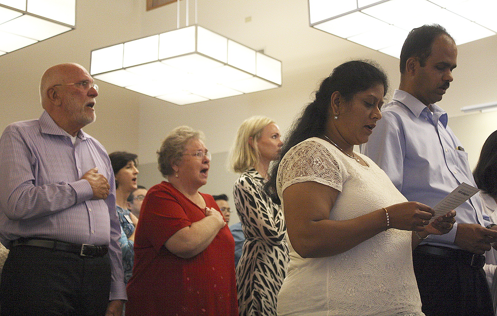Allison DeAngelis/Staff PhotoSinging the national anthem at their naturalization ceremony