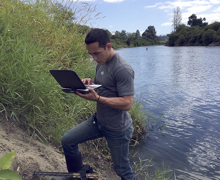 Josh Kubo from King County’s Water and Land Resources Division downloading data from a thermistor by Oxbow Farm.