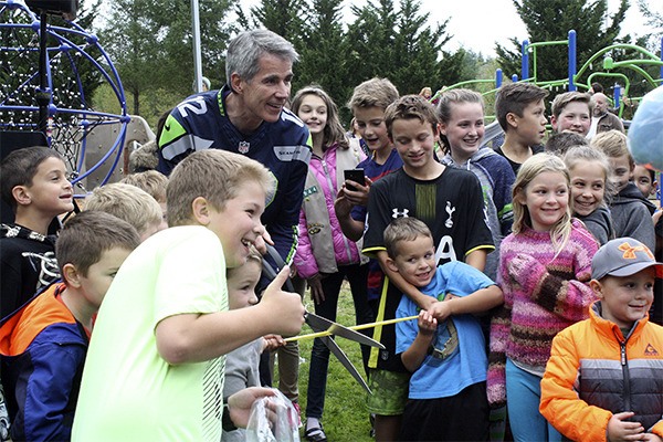Mayor Matt Larson cuts the ribbon at the grand opening of Fisher Creek Park with the help of the kids in attendance.