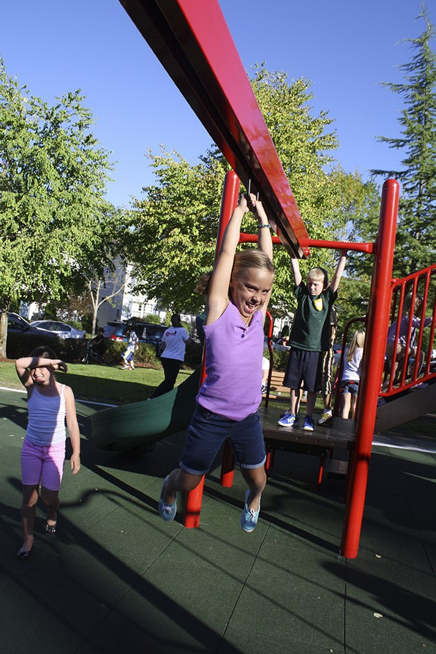 Maddie Forman swings across the playground on a zip-line-on rails.