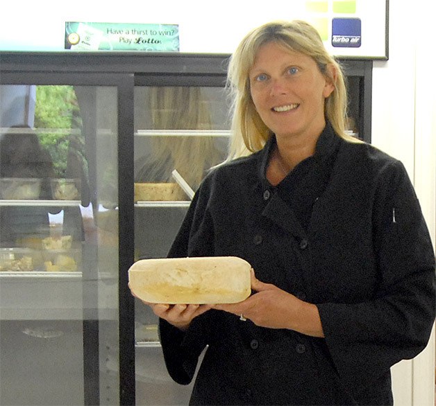 Julie Steil holds a small wheel of cheese