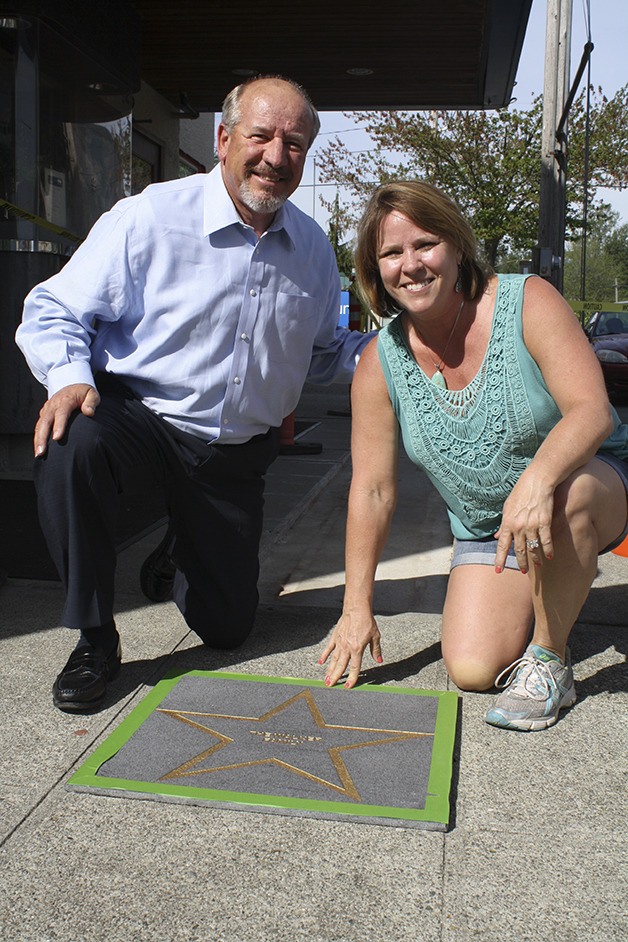 Owners Jim and Cindy Walker hold one of the granite stars used for the top-level donors to North Bend Theatre’s digital upgrade project. The stars went into the sidewalk in May.