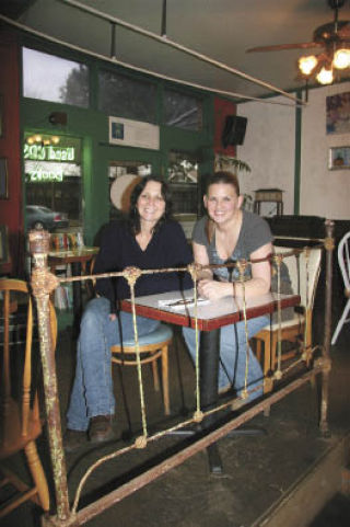 Former Isadaora’s Books and Cafe owner Cris Coffing sits at one of the eatery’s tables with new owner Jody Sands. The two have a close relationship. Coffing says Sands will make the downtown mainstay even better.