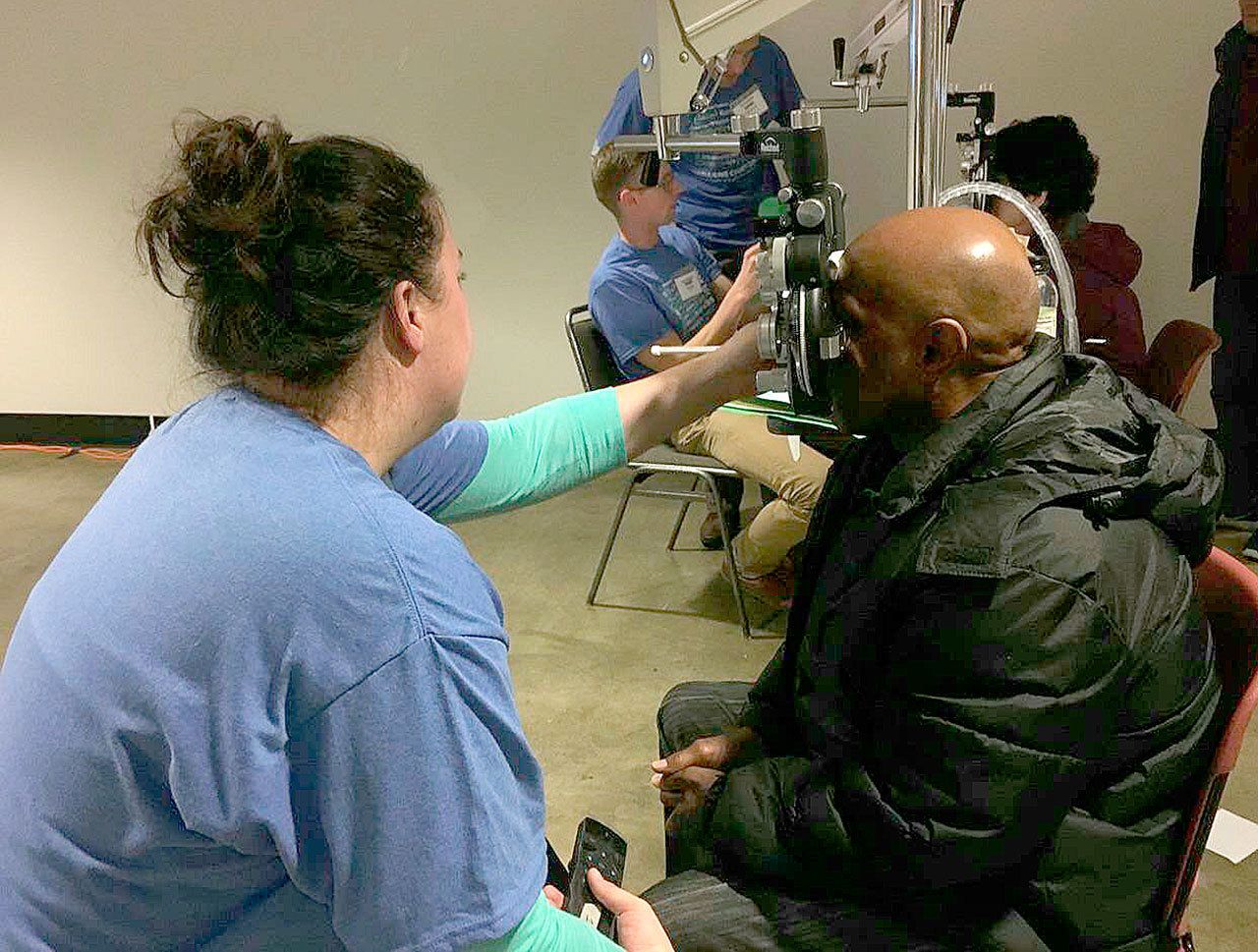 Sarah Field helps a patient at the Seattle King County Clinic in Seattle Center with a vision test.                                Courtesy Photo
