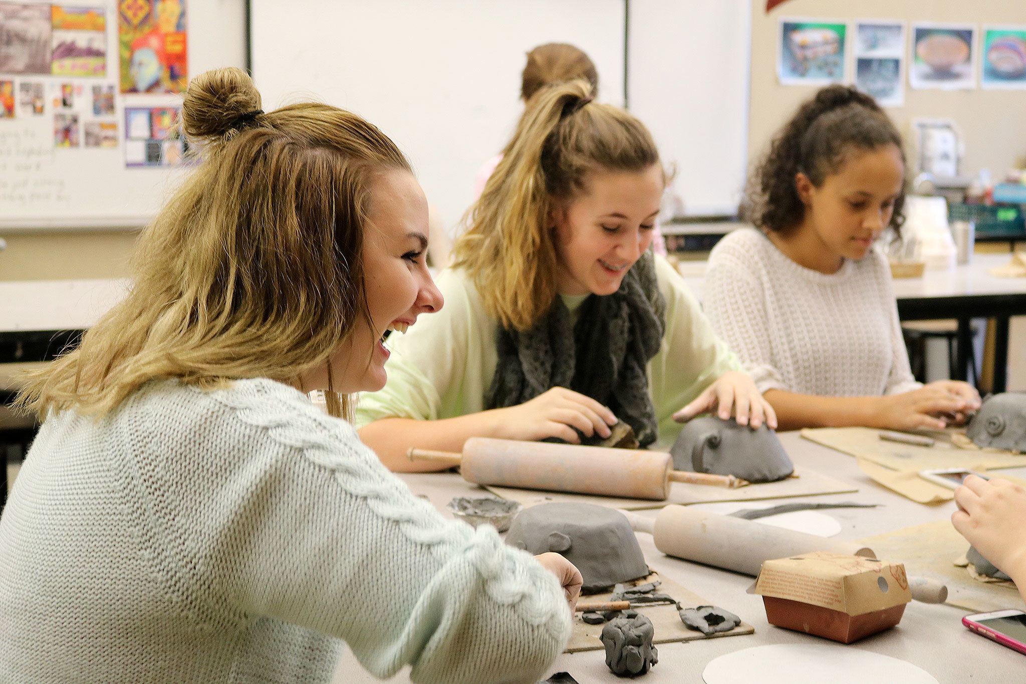 Evan Pappas/Staff Photo                                Ericka Michelson, Sami Lewiston and Josephine Araya, members of the Mount Si High School cheer team, laugh as they get to work in clay, creating dishes for the Empty Bowls dinner benefitting the Snoqualmie Valley Food Bank.