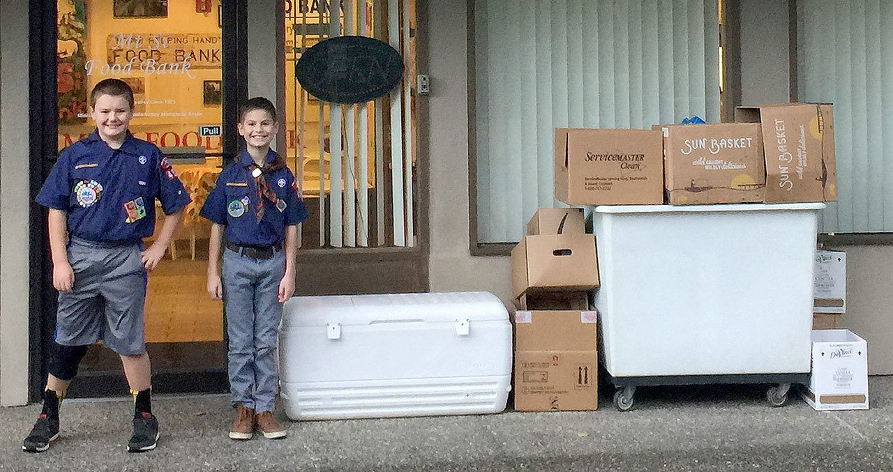 Cub Scouts Calen Munoz and Robby Shogren smile as they deliver more than 200 pounds of food donations to the Mount Si Food Bank.                                Courtesy Photo