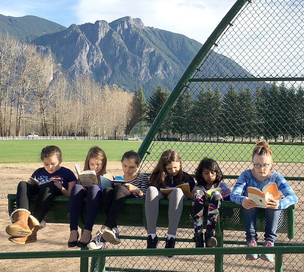 Curled up in the sunshine with their books are, from left, Elizabeth Conlon, Mallory Osborne, Taylor McCarthy, Kelsey Lingo, Taneesha Sharmin and Paige Horner, all students in Heidi Smith’s class who spent part of Thursday reading outside.