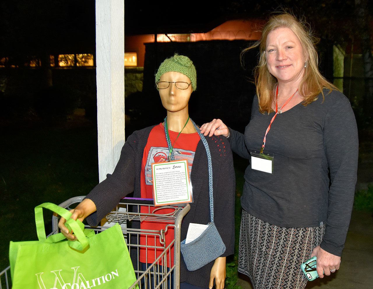 Snoqualmie Valley Food Bank director Heidi Dukich poses with ‘Lorna,’ who represents an actual food bank client, complete with issues in health, transportation and housing. The mannequins at the food bank’s open house introduced guests to the people getting help from the food bank.                                Carol Ladwig/Staff Photo