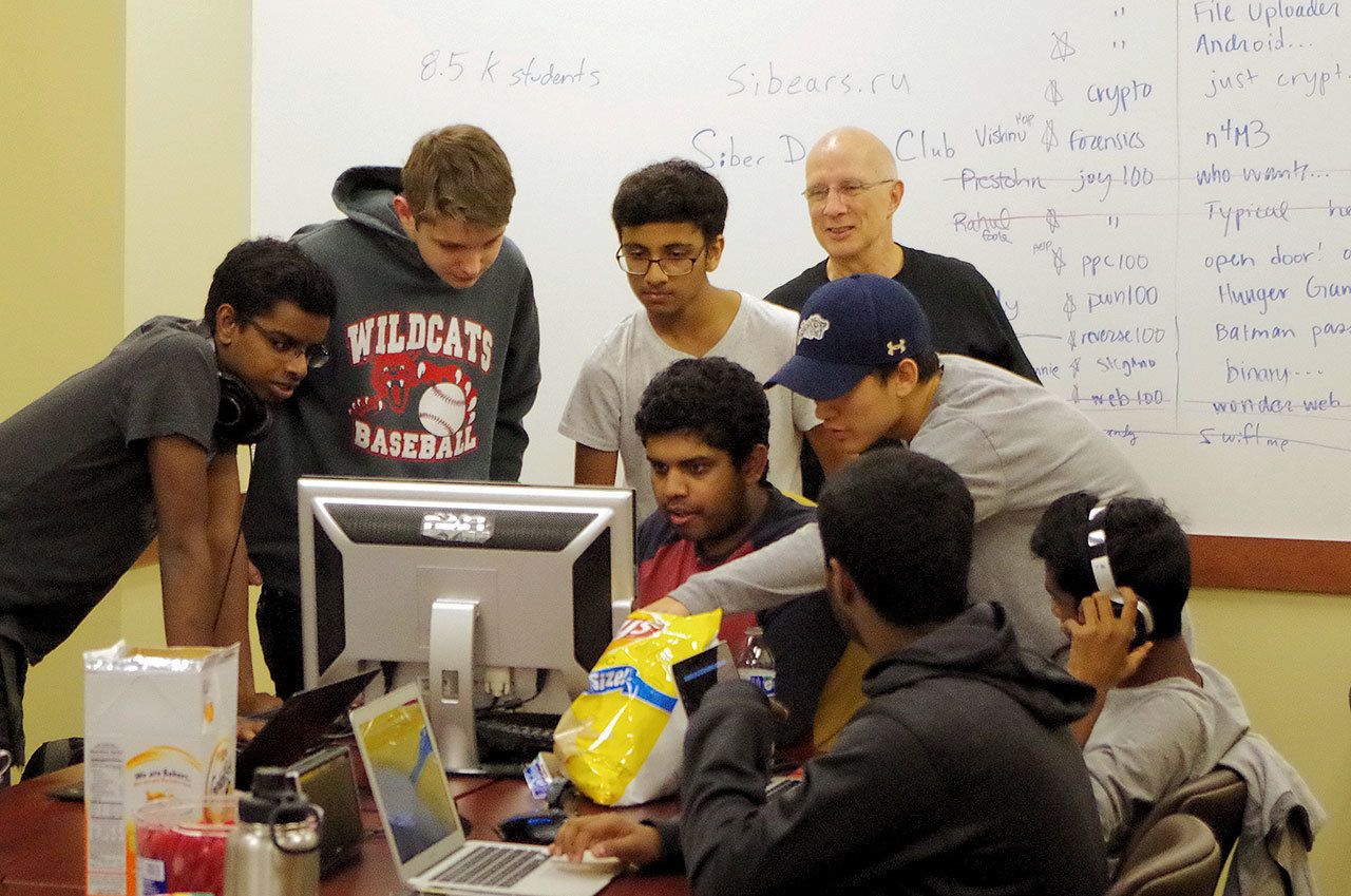 Students in the Siber Defense Club crowd around a computer to discuss how to solve a problem. (Courtesy Photo)