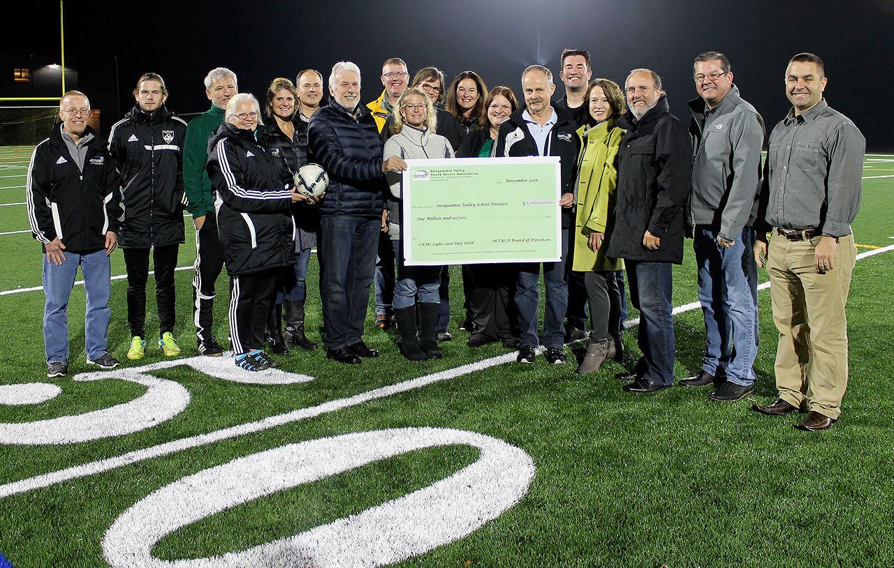 Snoqualmie Valley Youth Soccer Association board members and school board members gathered on the football field to celebrate the new CKMS sports field, and for the association to present a check to the Snoqualmie Valley School Board, Superintendent Joel Aune and Assistant Superintendent Ryan Stokes for the project.                                Courtesy Photo
