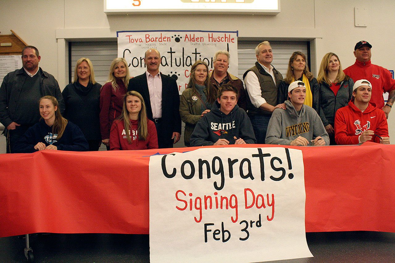 Celebrating National Signing Day, Mount Si students Camryn Buck, Tova Barden, Alden Huschle, Parker Dumas, and Colton Swain pose for a picture with their parents.                                Evan Pappas/Staff Photo