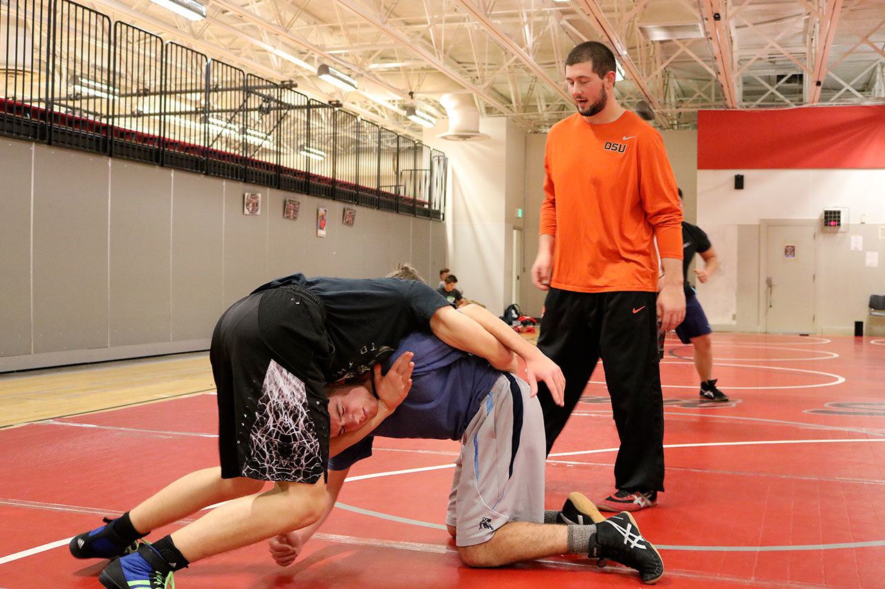 Coach Josh Mitchell instructs two students on technique during practice. (Evan Pappas/Staff Photo)