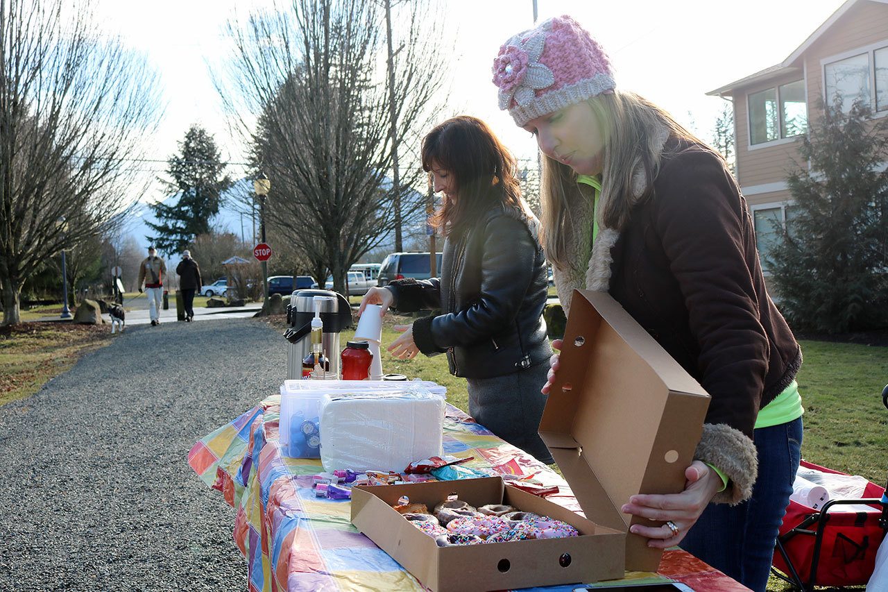 Kristen Zuray and Tonya Guinn set up a table of coffee and doughnuts for the Trail Youth project, which officially came to Snoqualmie Valley on Tuesday. The group aims to help connect teens and young adults who are struggling, with resources that can help them.                                Evan Pappas/Staff Photo