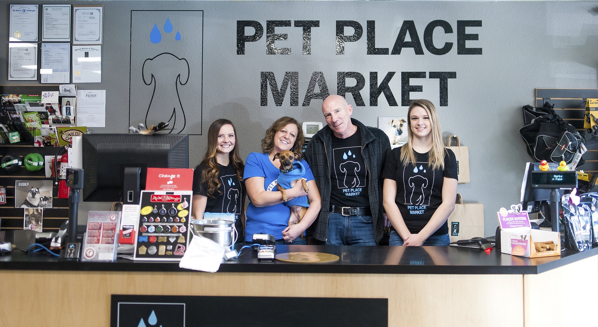 Staff at Pet Place Market include from left are: Megan, store manager Wendi Beerbower, holding company dog Jazzy, owner Chris Creighton, and Stormy.                                Courtesy Photo