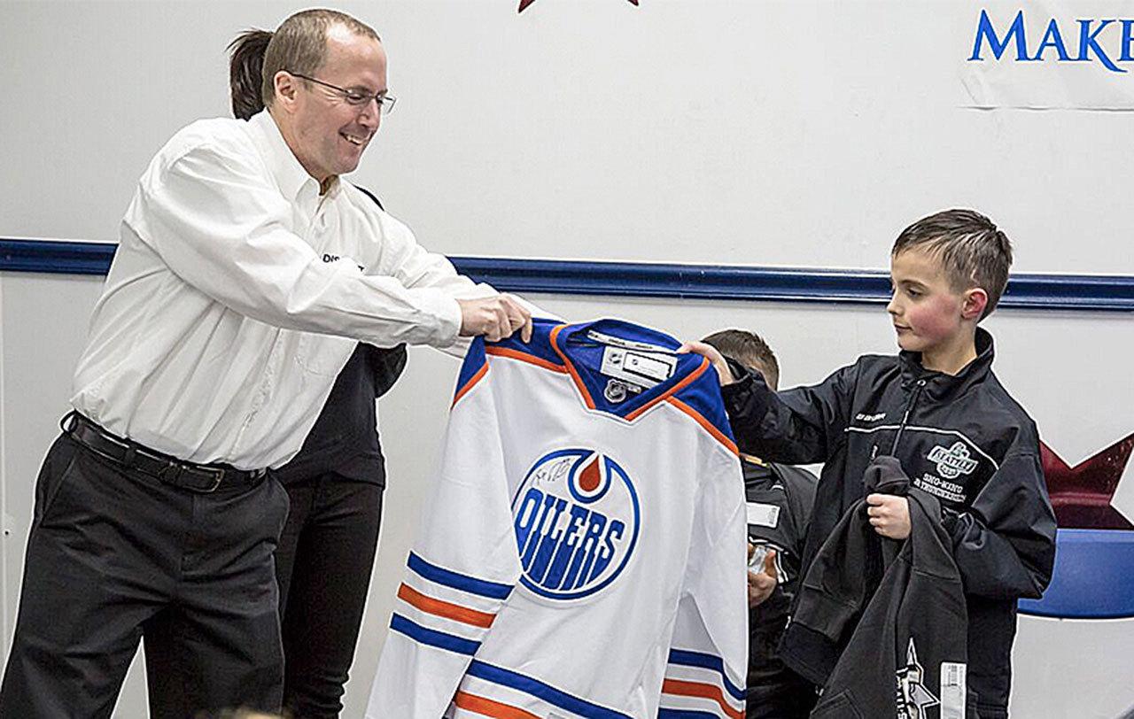 Zach receives an autographed Oilers jersey from Make-a-Wish.                                Courtesy Photo