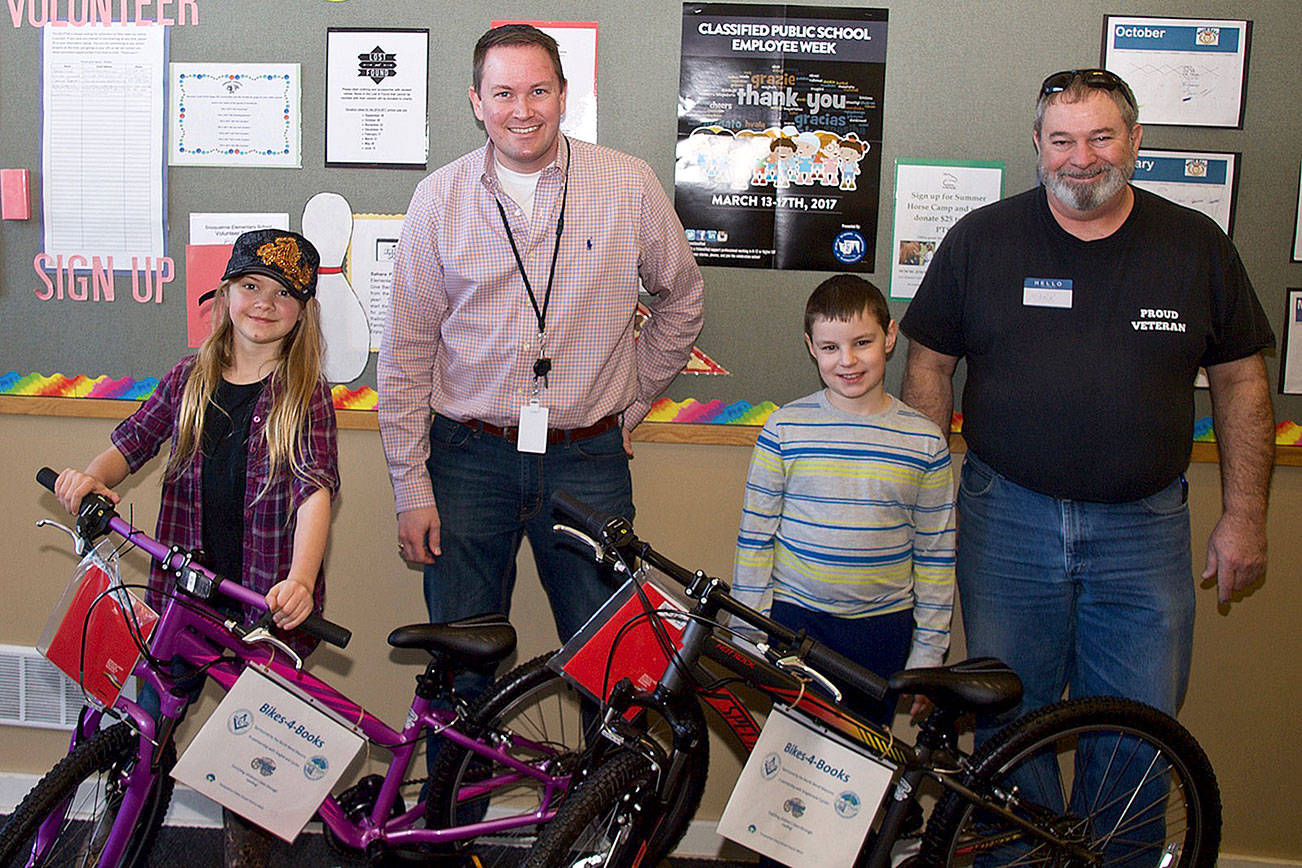 Snoqualmie Elementary School third graders Zoe Hendricks, left, and Carter Cantrell, received bikes and helmets through the North Bend Masons&rsquo; Bikes for Books program, Pictured with the students are SES principal John Norberg, left, and Mark Goodwin, North Bend Masons.                                (Courtesy Photo)