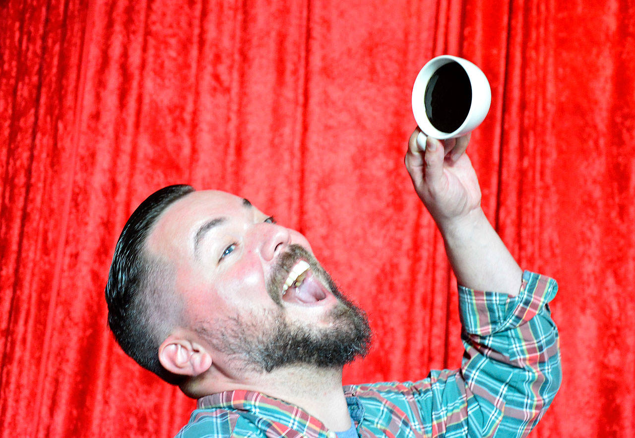 A fan mugs with a fake cup of coffee as part of the Red Room set in Compass Outdoor Adventures.                                (Mary Miller Photo)