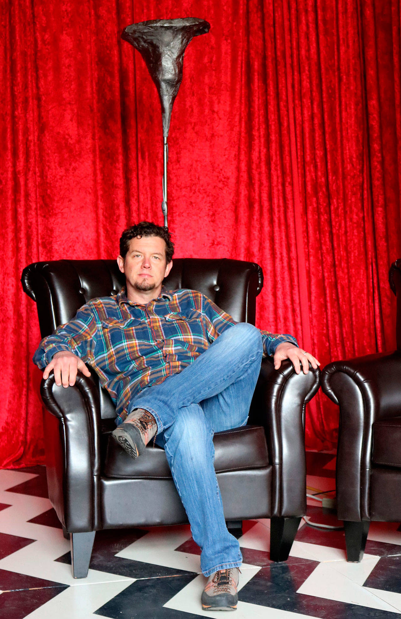 Luke Talbott, owner and CEO of Compass Outdoor Adventures, takes a seat in the red room inside his business.                                (Evan Pappas/Staff Photo)