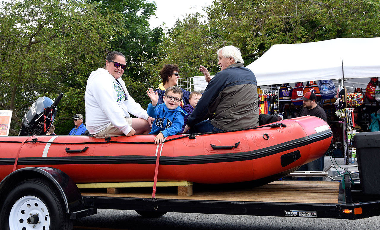 A young boy on the Fire District 27 rescue boat float waves to the camera.                                Carol Ladwig/Staff Photo