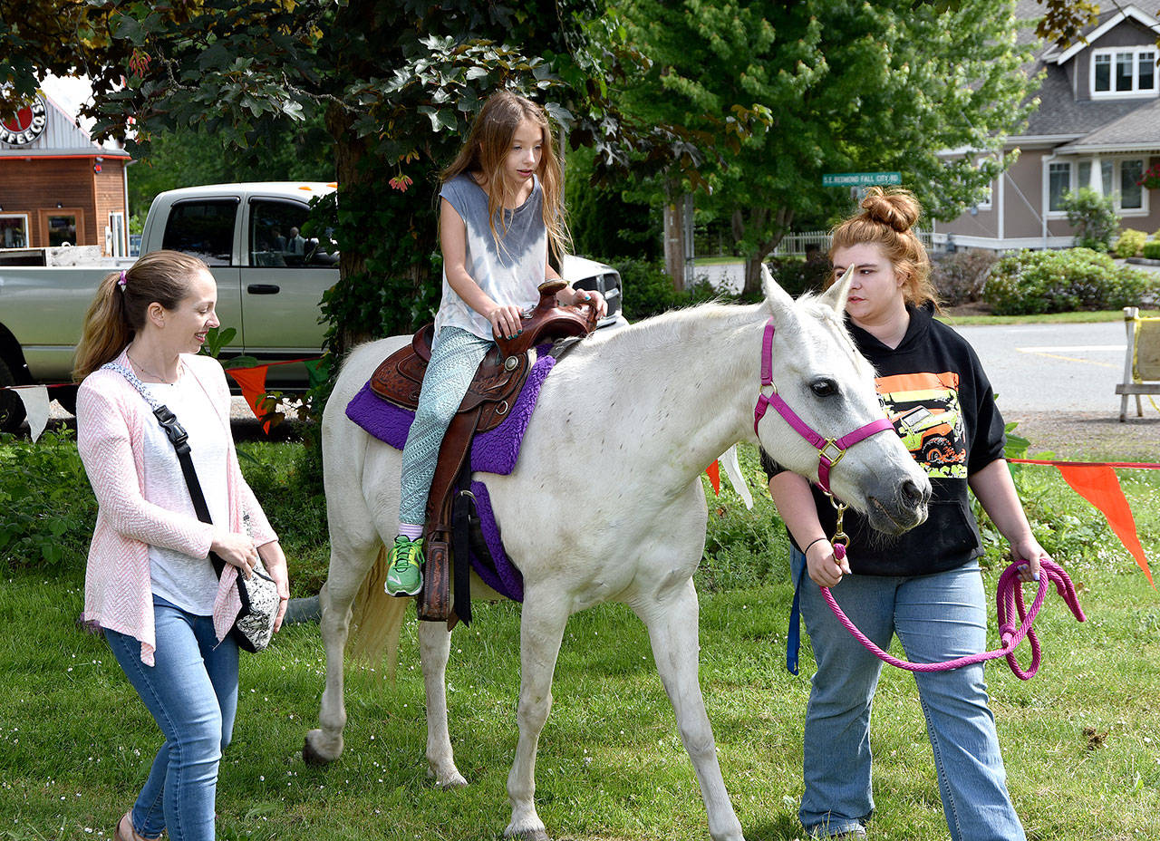 Ariana Zirkle, 8, enjoyed a pony ride Saturday at Fall City Day with her mother, Rachael. Next to go into the saddle was younger sister Emily.                                 (Carol Ladwig/Staff Photo)