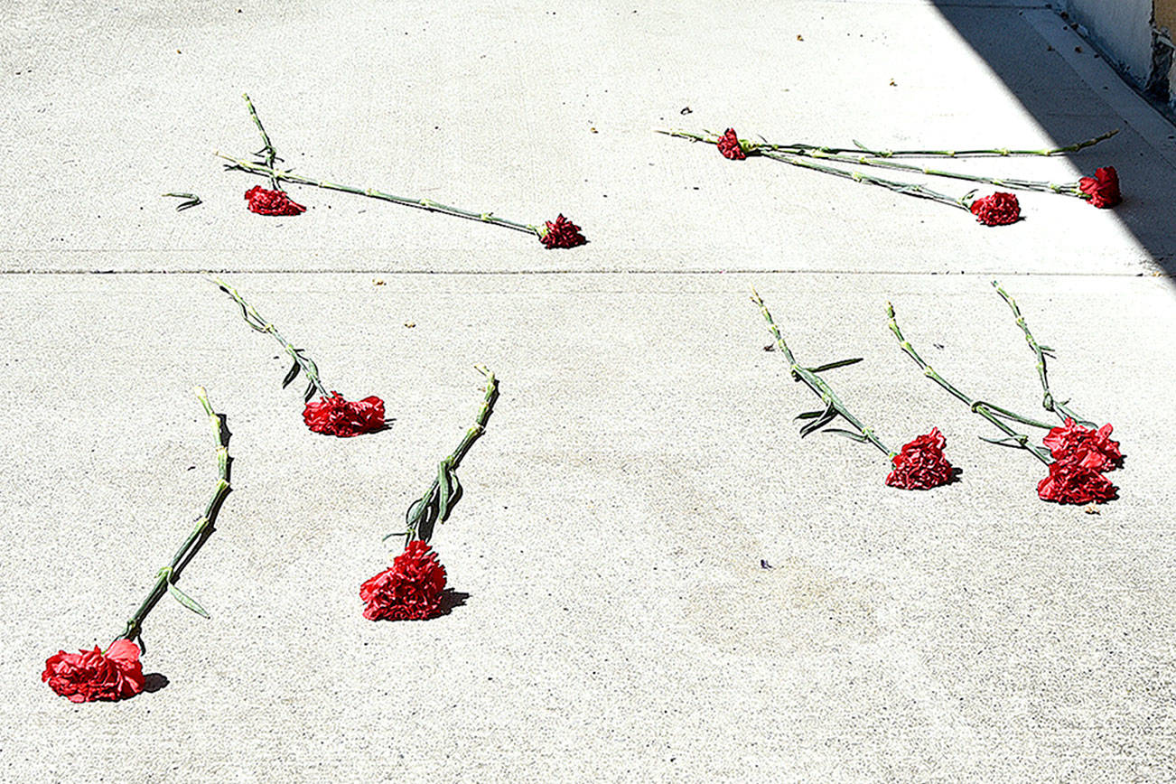 Flowers are sprinkled on the sidewalk in memory of the Snoqualmie woman who died after a fall Saturday.