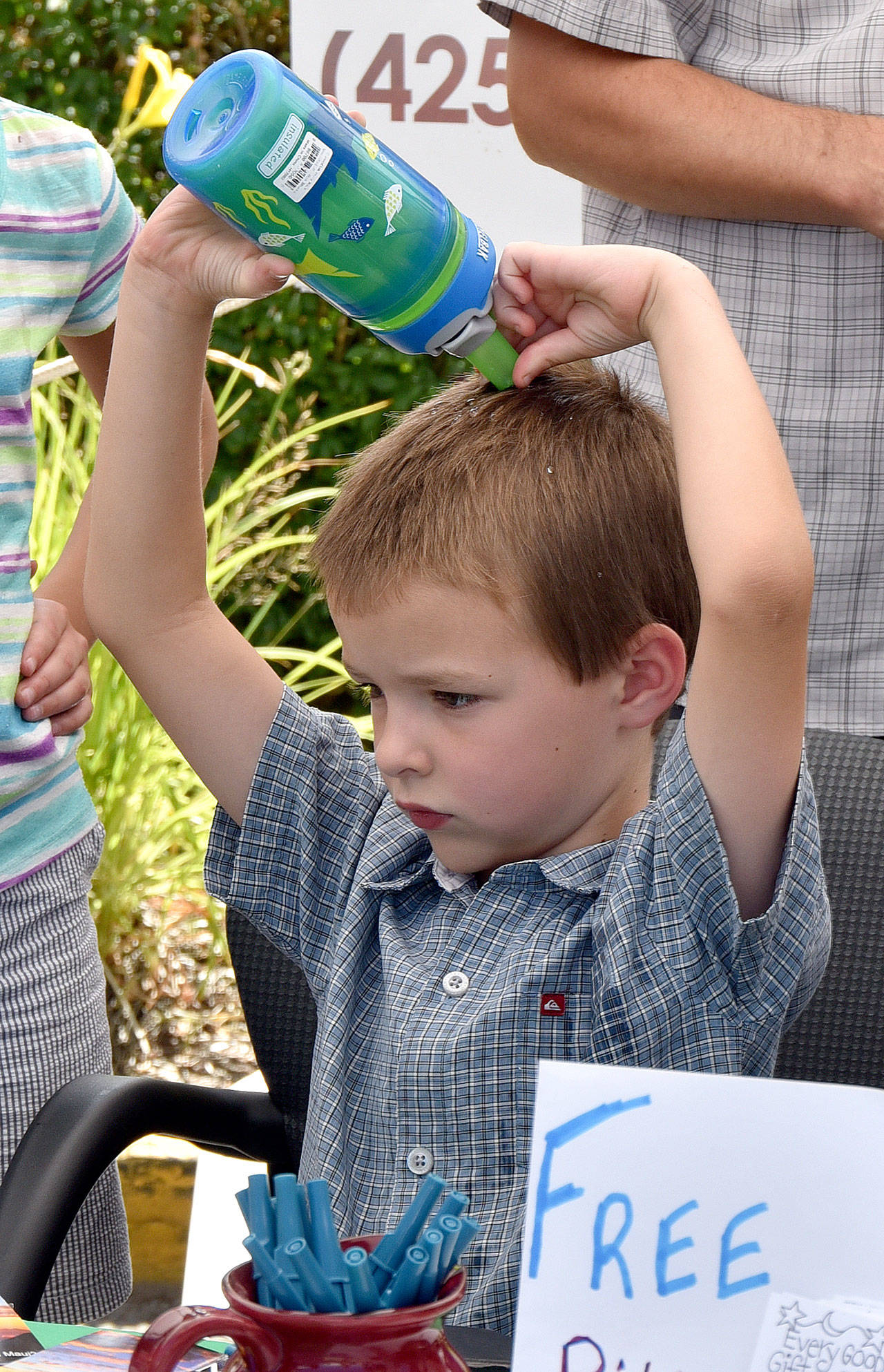 Samuel Nearn beats the heat Saturday by squeezing a water bottle over his head. Carol Ladwig/Staff Photo