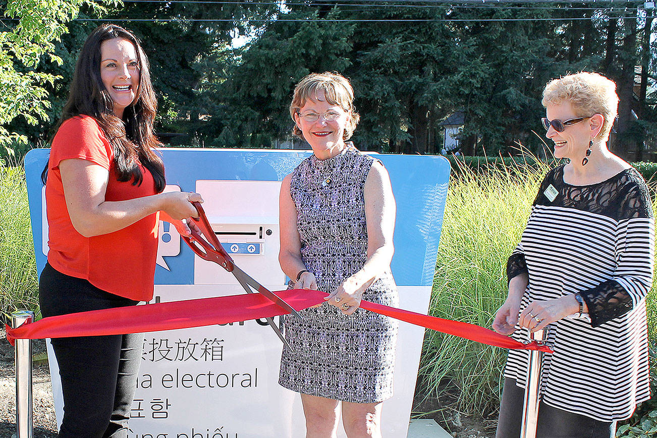 Councilmember Kathy Lambert, center, Elections Director Julie Wise, and Michele Drovdahl of the King County Library System, cut the ribbon on the new election drop box in front of the Fall City Library.                                Courtesy Photo