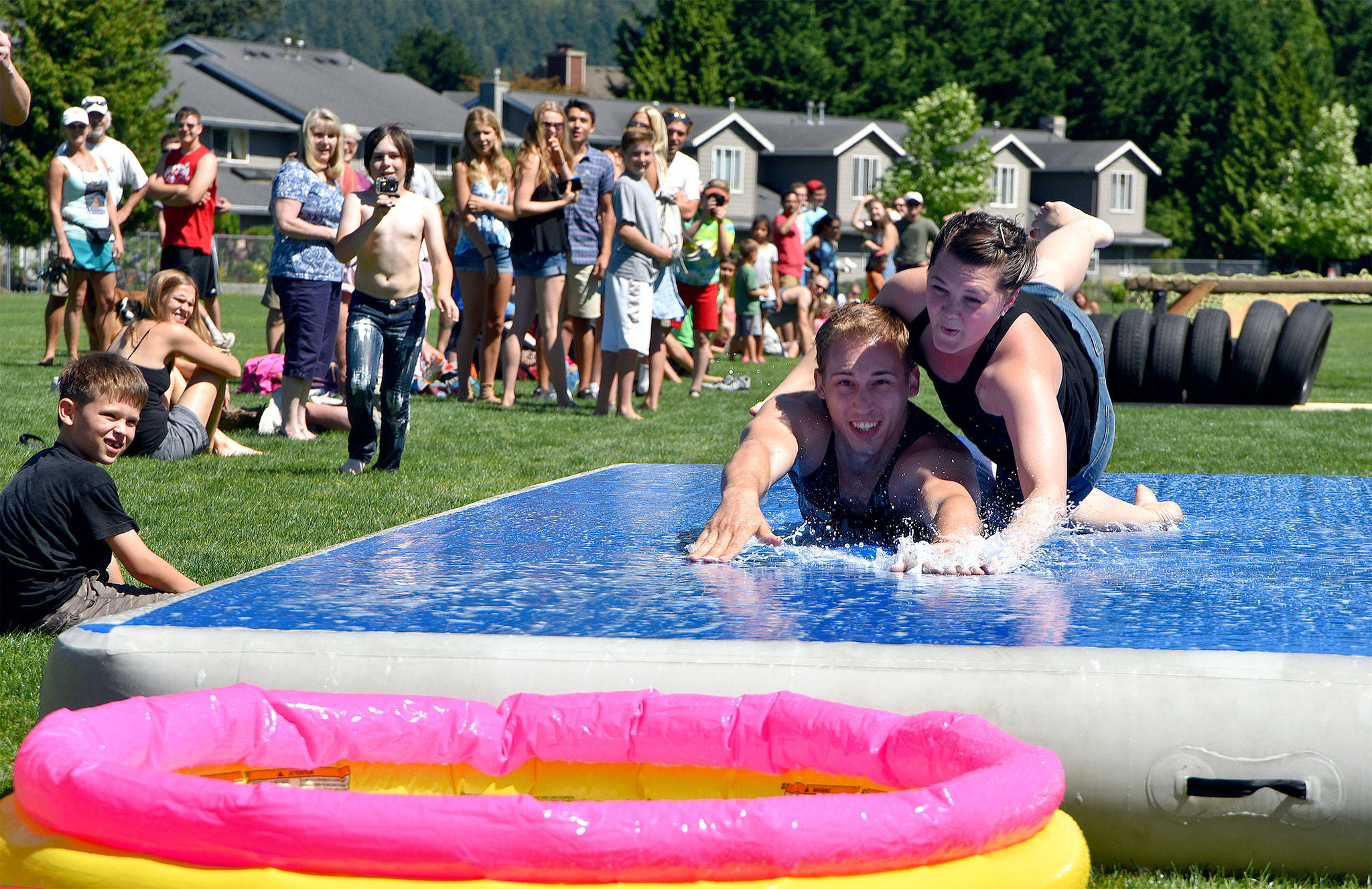 Chris and Jamie Teteak slip and slide their way to victory in the 2016 Festival at Mount Si wife-carrying contest. This year’s event includes an under-21 event, a sibling-carrying competition to win your partner’s weight in root beer.                                (Carol Ladwig/File Photo)