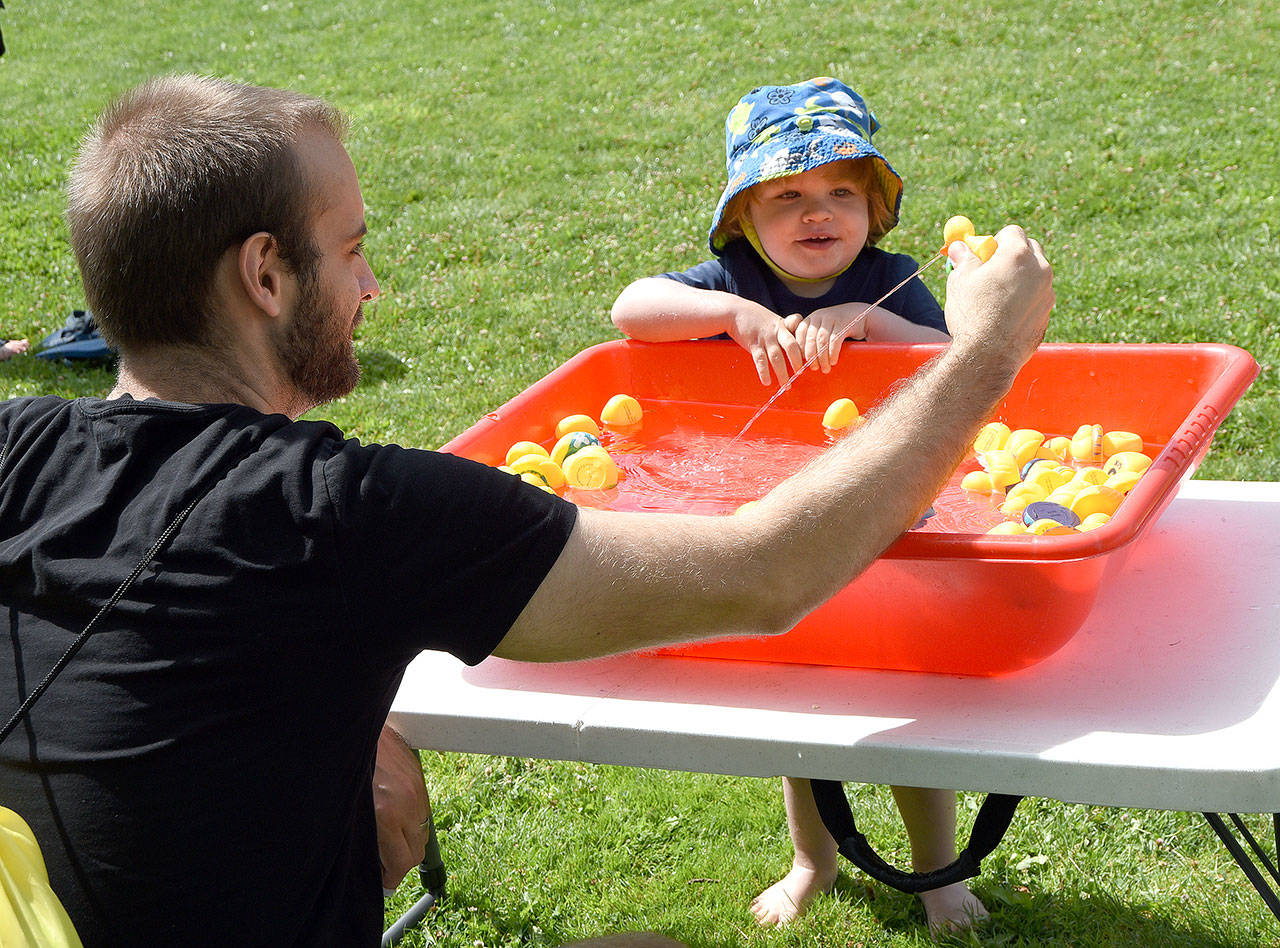 Dan Ruth and his son Mars play with rubber duckies. (Carol Ladwig/Staff Photo)
