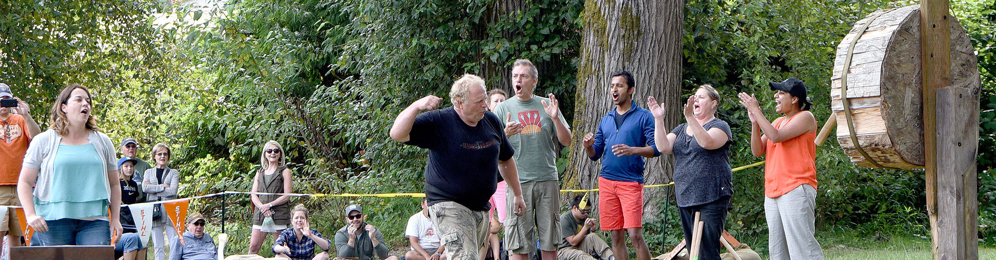 The crowd celebrates a near-perfect axe throw by a contestant Sunday during the timber sports demonstration in Sandy Cove Park.                                (Carol Ladwig/Staff Photo)
