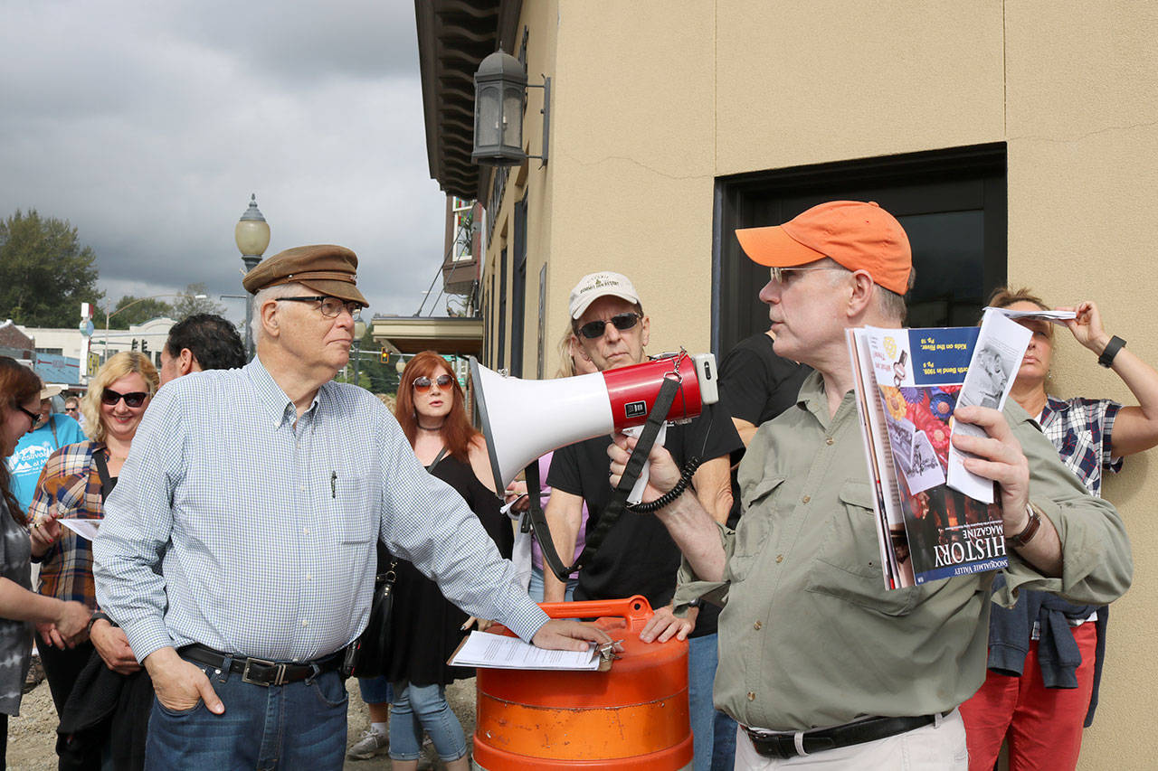 Gardiner Vinnedge and Dave Battey pass their new megaphone back and forth as they discuss the history of the buildings in downtown North Bend. (Evan Pappas/Staff Photo)