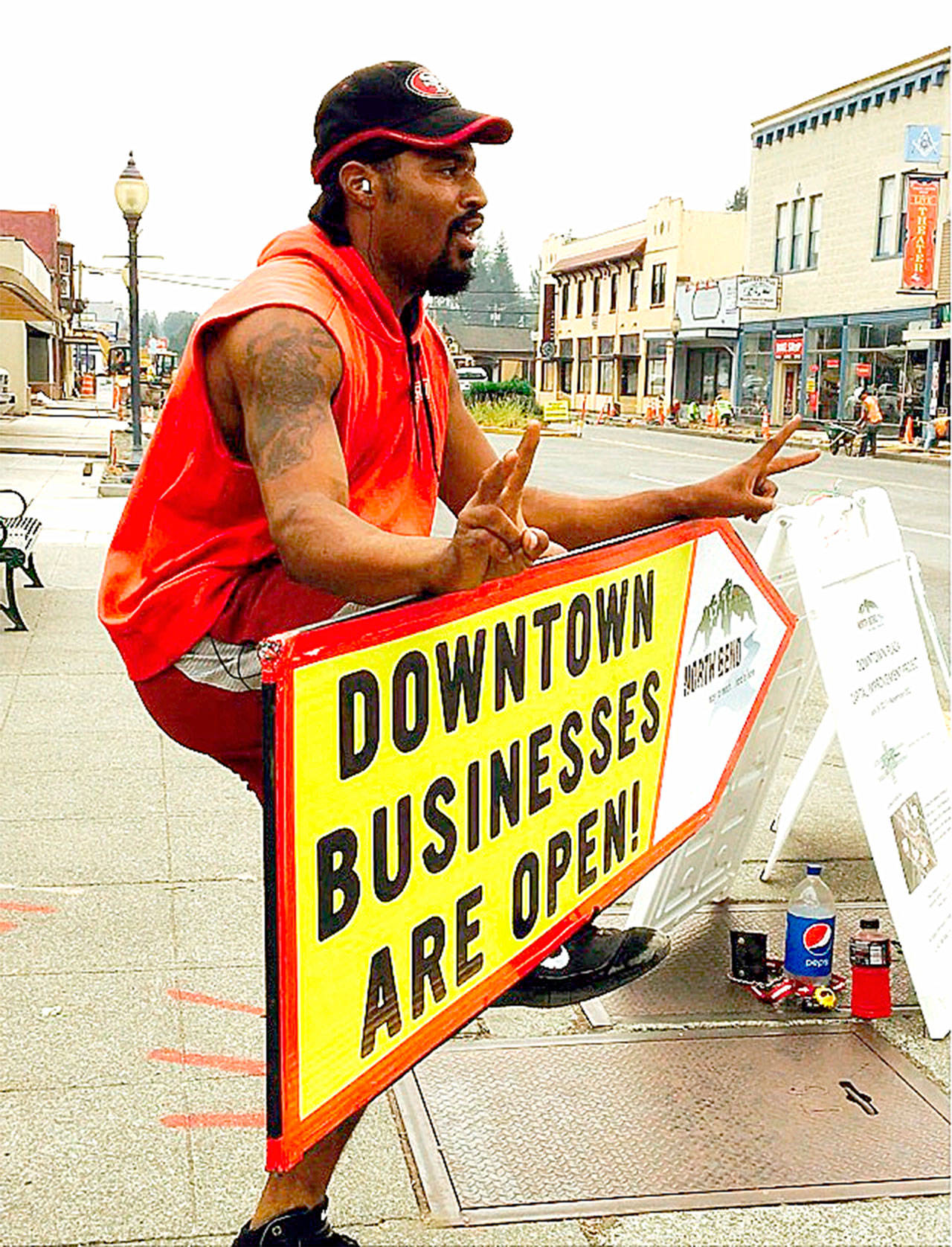 Sign spinner advertises for downtown North Bend businesses, affected by construction work