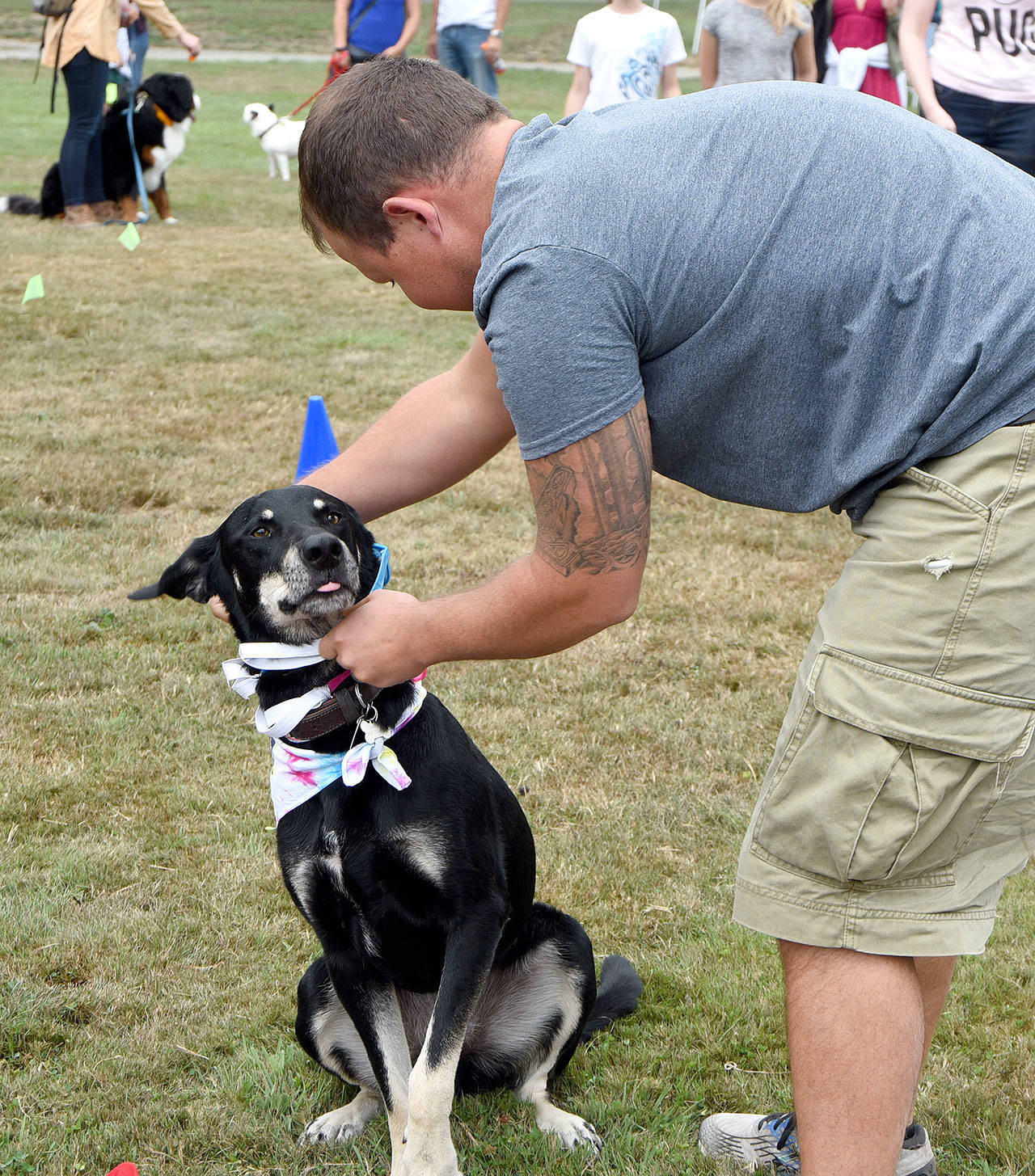 Aaron Cowling of North Bend, dresses his dog, Toby, in the Dress for Success contest. They took second place for taking the least time to get dressed and crossing the finish line with the most articles of clothing still on Toby.(Carol Ladwig/Staff Photo)