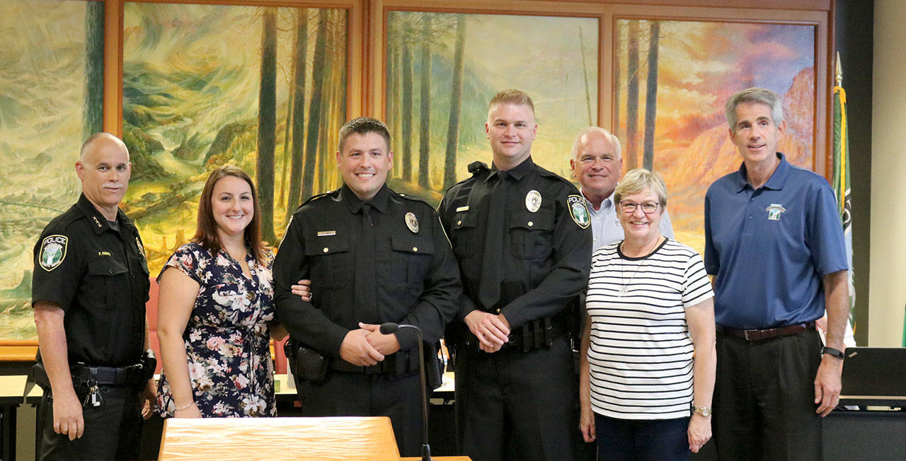 The city of Snoqualmie welcomed two new officers to the police department at their swearing-in ceremony at the Aug. 28, city council meeting. From left: Police Chief Perry Phipps, Lindsay Jones, Officer Evan Jones, Officer James Kaae, Ken Kaae, Gail Kaae and Mayor Matt Larson. (Evan Pappas/Staff Photo)