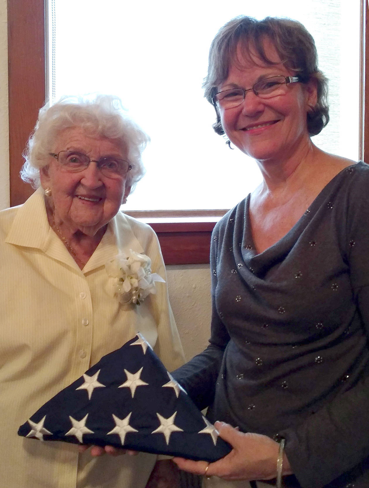 Pearl Moore accepts the U.S. flag that was flown over the Capitol in honor of her 100th birthday, Sept. 18, from King County Councilwoman Kathy Lambert. (Courtesy Photo)