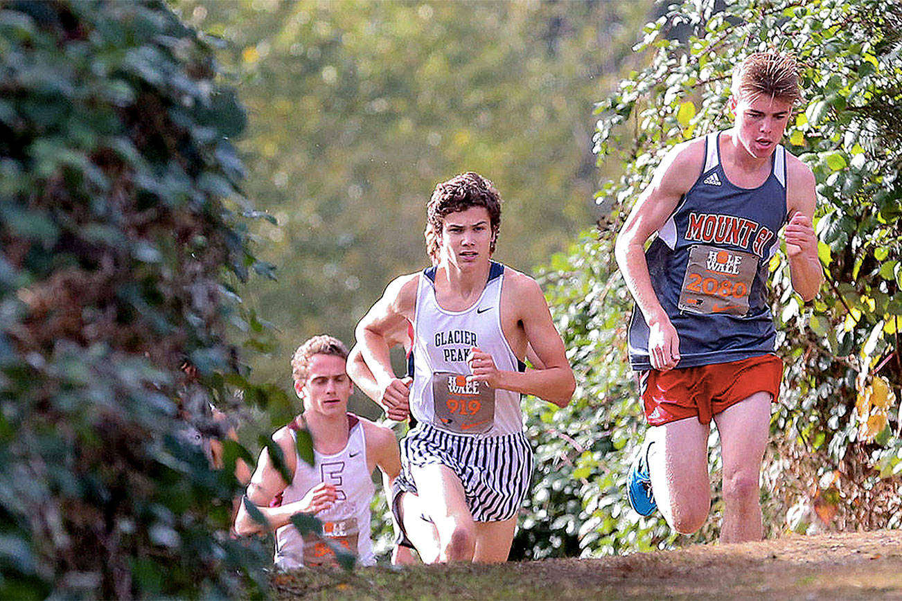 Mount Si’s Joe Waskom, right, leads the pack Oct. 7 during the 34th annual Hole in the Wall Cross Country Invitational at Lakewood High School in Arlington. (Kevin Clark / The Herald)