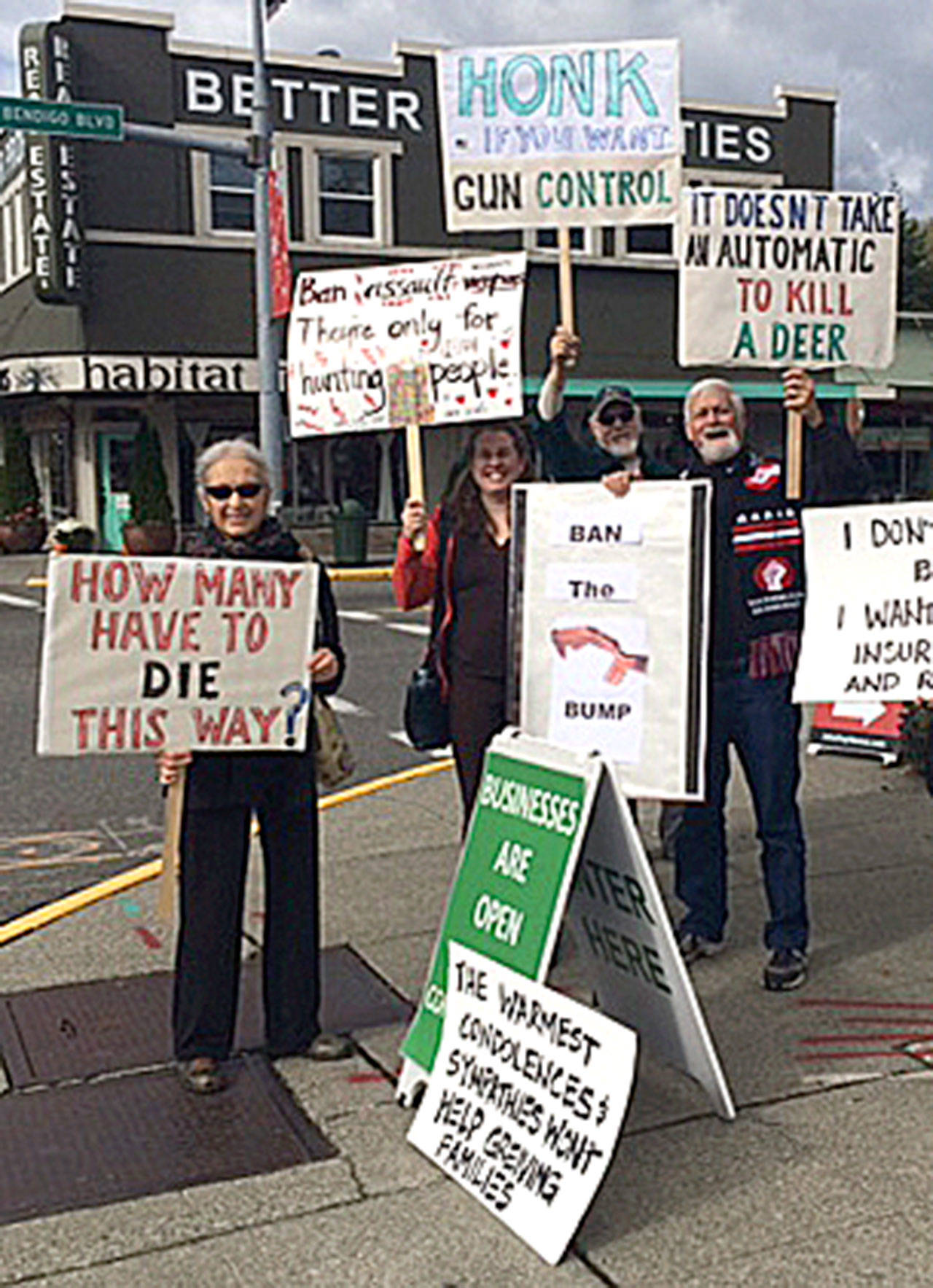 Members of Snoqualmie Valley Indivisibles dressed in black and waved signs calling for gun control, Oct. 8, in downtown North Bend. (Courtesy Photo)