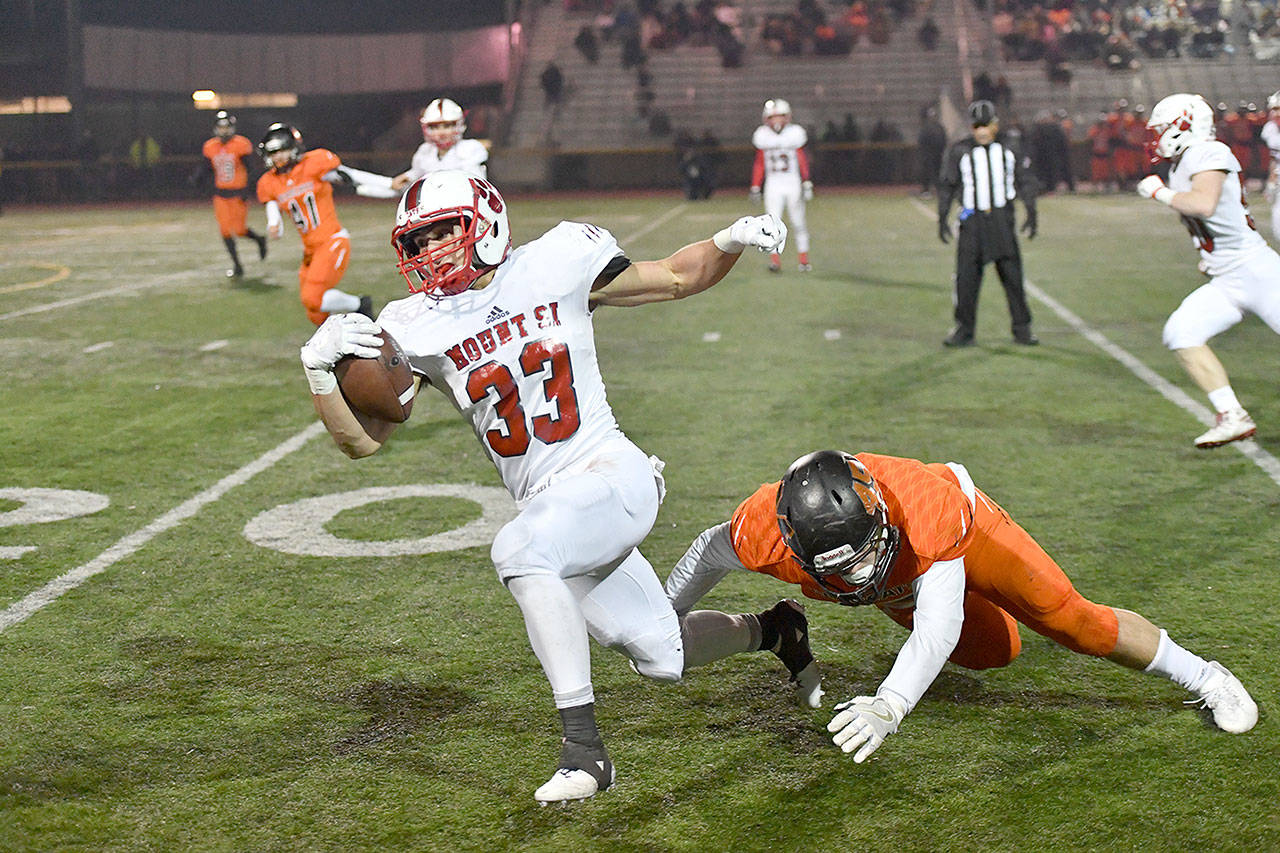Paine Smith makes a quick getaway as a Monroe player makes a dive for him. The Mount Si Varsity Football team lost their first playoff match against Monroe High School in a close 44-40 game on Friday, Nov. 3. (Photo courtesy of Calder Productions)