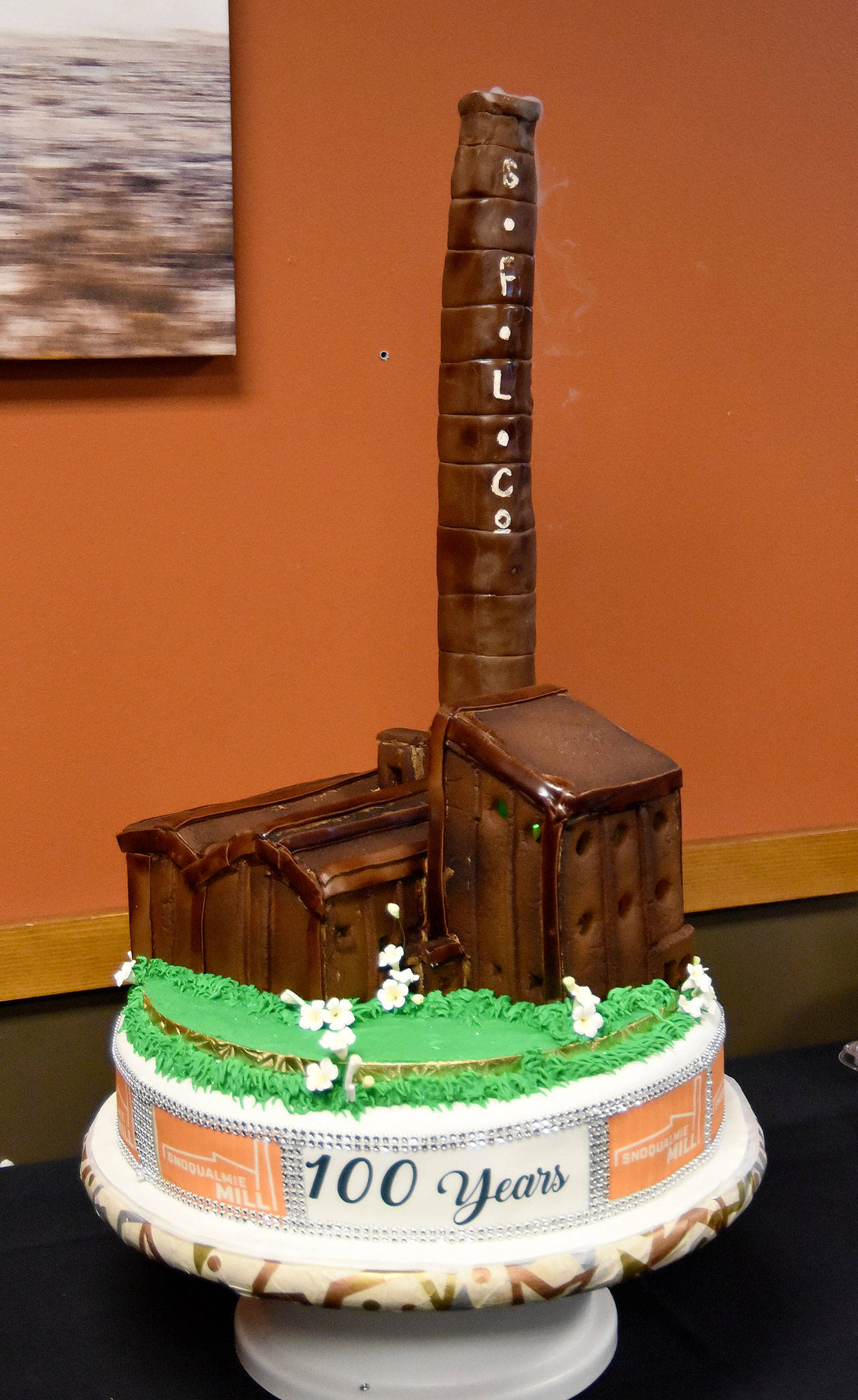 A 100th anniversary cake, featuring a gingerbread replica of the mill’s powerhouse, was featured in Saturday’s celebration. (Carol Ladwig/Staff Photo)