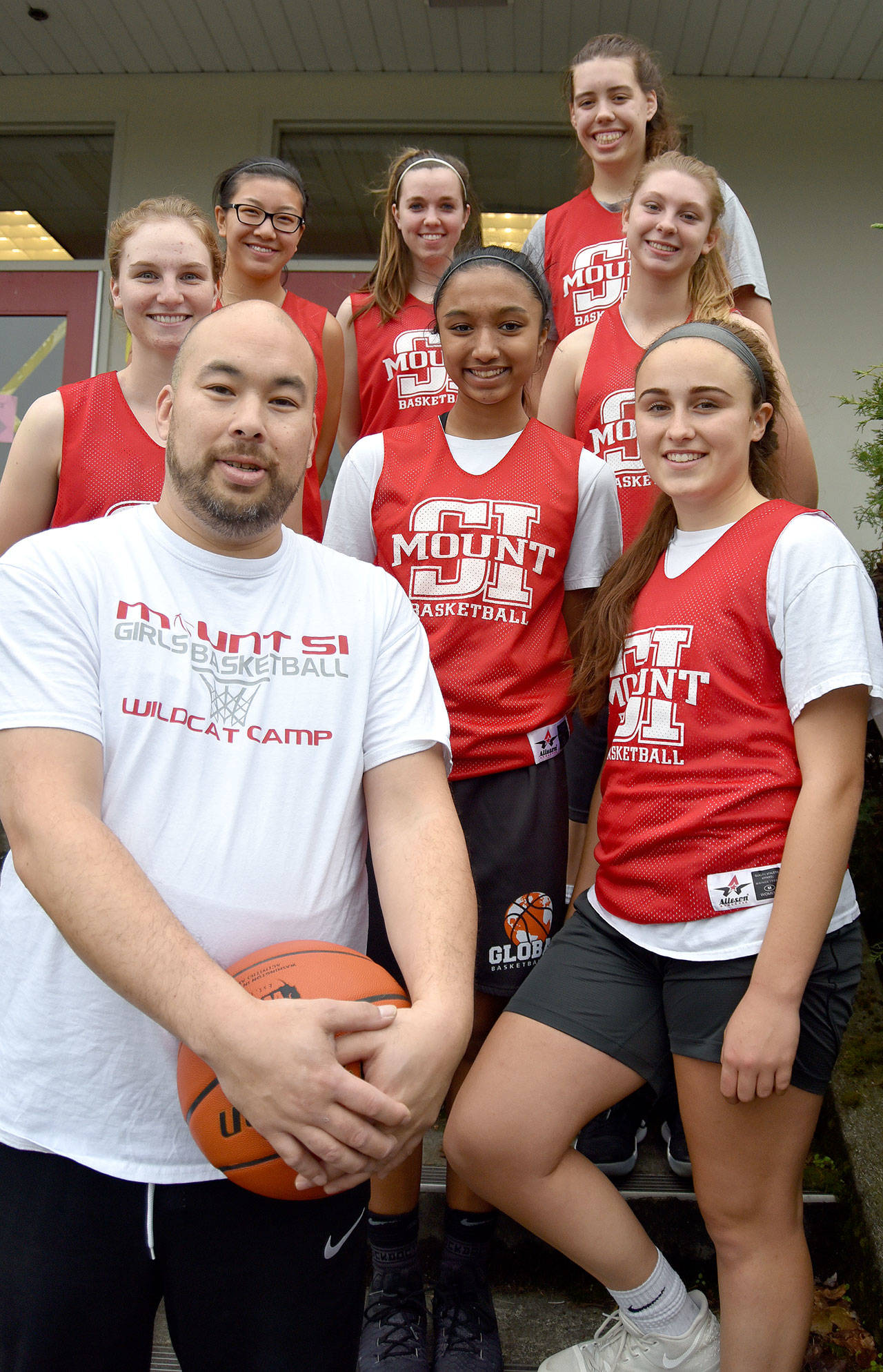Members of the Mount Si High School varsity girls basketball team finished practice Saturday with a photo with their new coach. Pictured from left are: front - Head Coach Jason Marr and Izzy Smith; middle - Lauren Wilbourne, Nitika Kumar, and Joelle Buck; back - Aliea Bliven, Jenae Usselman and Selah Heide. Sam Smith is missing. (Carol Ladwig/Staff Photo)