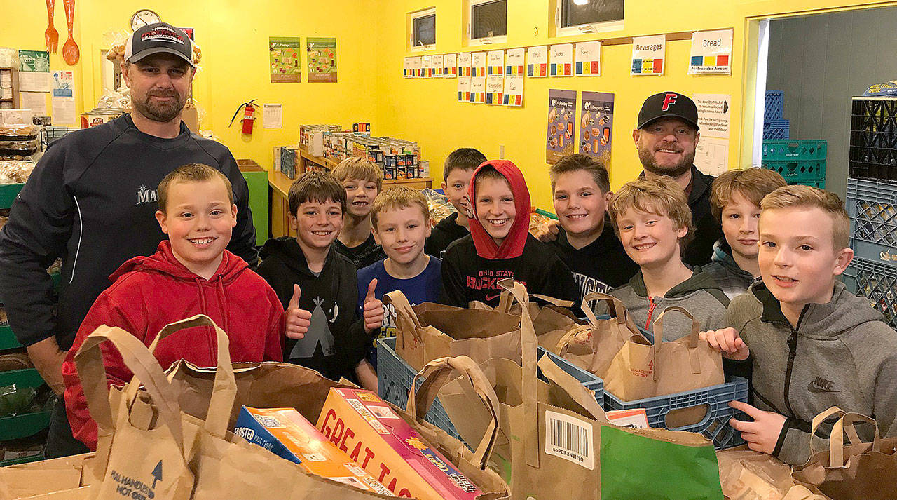Players and coaches of the Wildcat Baseball Club pose for a photo after delivering a donation to the Snoqualmie Valley Food Bank. The players organized the drive to include a community service element to their team involvement.                                Courtesy Photo