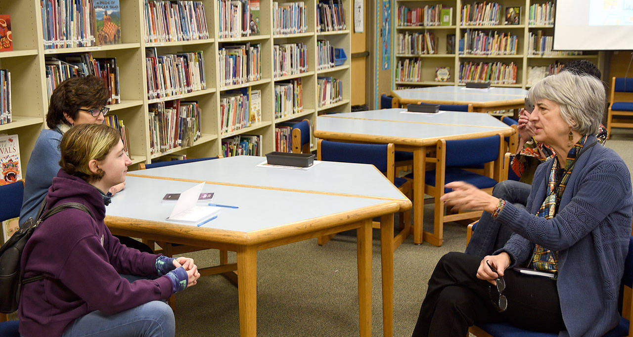 Jay Dilger answers questions about her book from teacher Marianne Bradburn, left, and librarian Nancy Huestis in the Opstad Elementary School library. (Carol Ladwig/Staff Photo)