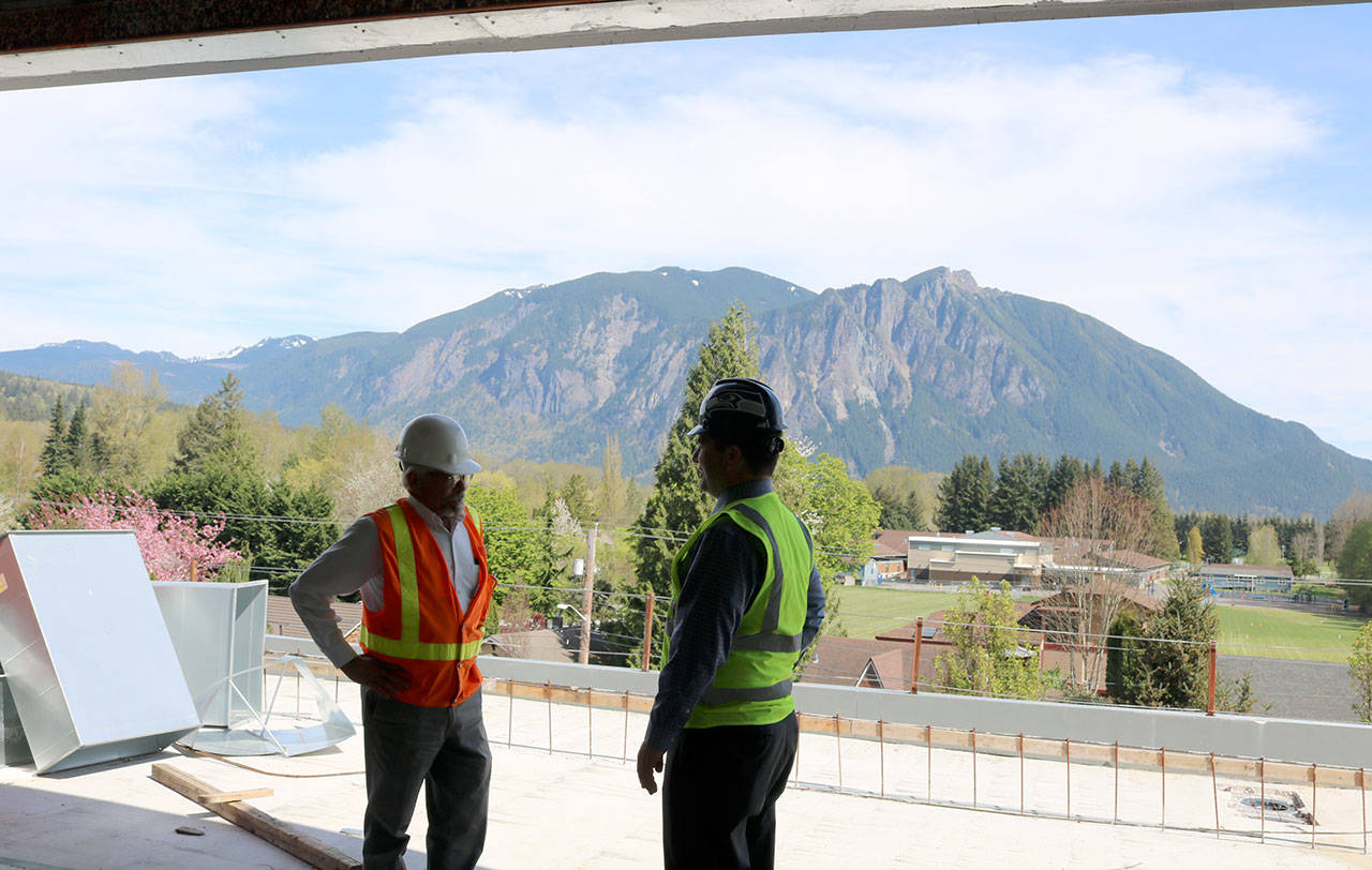 Marsh and Stokes talk by an open wall with a view of Mount Si in the background. Evan Pappas/Staff Photo