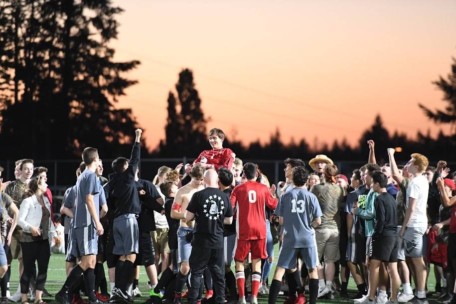 The adoring crowd gives Colby Ramsey a lift after he converted the game-winning penalty kick against Issaquah. Photo courtesy of Calder Productions