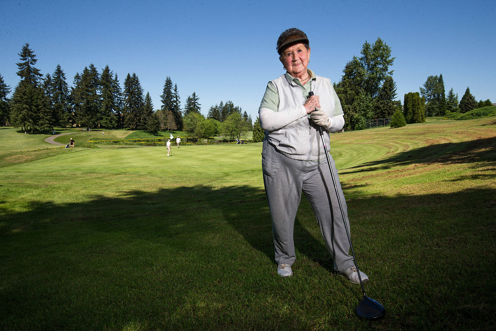 91-year-old golfer Bette Moore stands along on the 14th hole at Walter Hall Golf Course in Everett on Tuesday. Moore recently hit a hole-in-one on the hole. (Andy Bronson / The Herald)